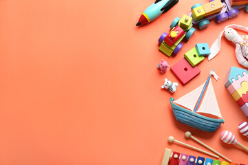 Different toys on orange background, flat lay. Space for text