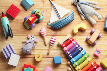Different toys on wooden background, flat lay