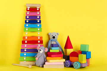 Set of different toys on yellow background