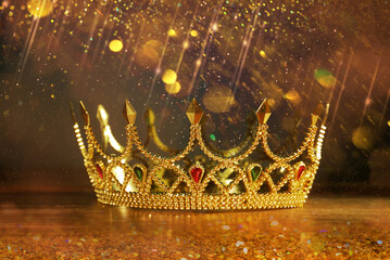 Fantasy world. Beautiful golden crown on table, bokeh effect