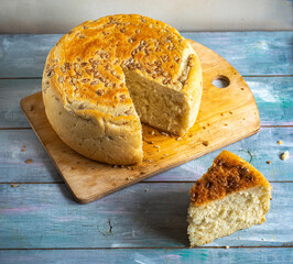 White homemade bread in a cut and a piece of bread on a wooden table top view