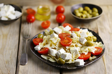 Selective focus. A plate of pasta with feta cheese and olives. Delicious healthy dinner. Italian style.