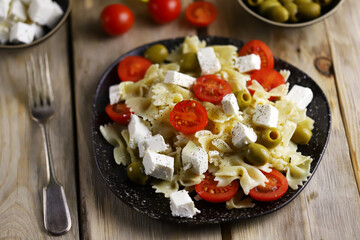 Selective focus. A plate of pasta with feta cheese and olives. Delicious healthy dinner. Italian style.
