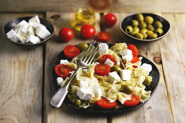 Selective focus. A plate of pasta with feta cheese and olives. Delicious healthy dinner. Italian style.