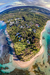 Aerial drone panorama view of the peninsula with paradise beach with palm trees, tropical villas...