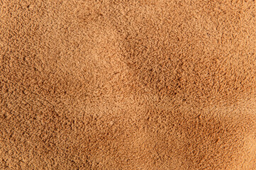leather grunge background: an old piece of tough camel skin, with scuffs, spots, scars