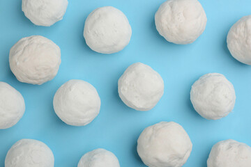 Fototapeta na wymiar Round snowballs on light blue background, flat lay
