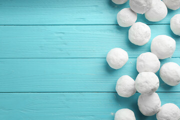 Snowballs on light blue wooden background, flat lay. Space for text