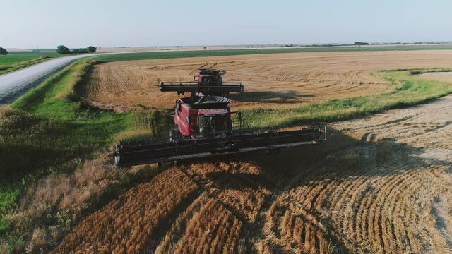 Two combine harvesters move through a field
