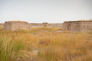 Sod Topped Buttes in Badlands National Park, South Dakota with a field of dried grass in the...