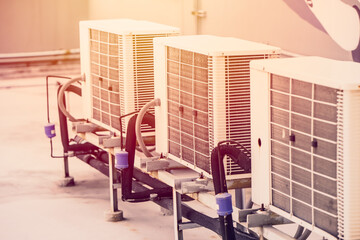 Fototapeta na wymiar row of air conditioner compressor unit setup outdoor office building with hot summer season weather.