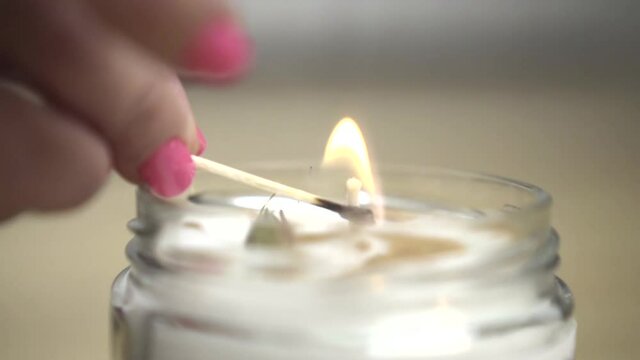 WOMAN FIGERS LIGHTING A CANDLE WITH A MATCH FOR MEDITATION HOLISTIC SLOW MOTION CLOSE UP