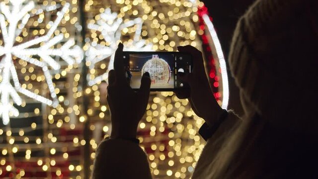 Woman Taking Pictures of a Christmas Lights - Close-up of a Mobile Phone