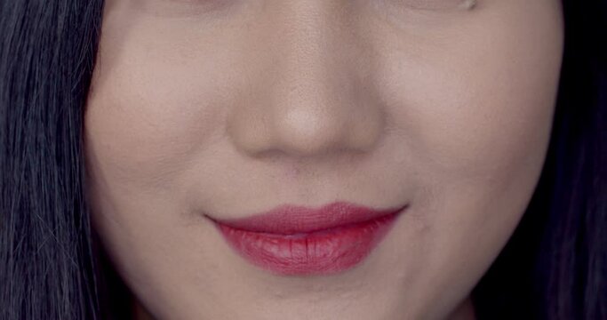 Close up female lip smiling and biting lips in shyness