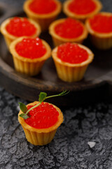 Appetizing tartlets with red caviar and microgreen decor. Holiday concept. Close-up.