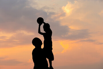 Fototapeta na wymiar Silhouette of father and son with ball evening sky sunset background, Sport and enjoying life concepts.