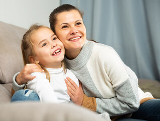 Happy family woman with small daughter laughing at home interior