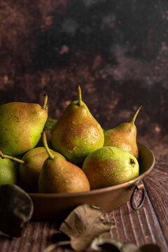 Fresh raw pears in a copper baking pan
