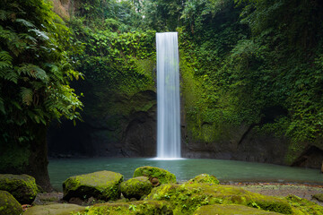 Waterfall landscape. Beautiful hidden waterfall in tropical rainforest. Nature background. Slow shutter speed, motion photography. Tibumana waterfall, Bali, Indonesia