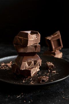 Stack of chocolate cubes on black background