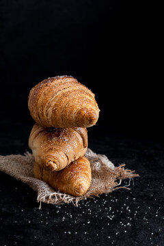 Three Brioche Croissants over Dark Background