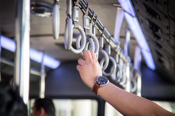 Hand of passenger holding in shuttle bus during transfer to aircraft