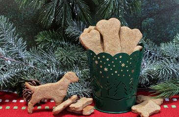 Dog bone cookies in a container in a Christmas setting.