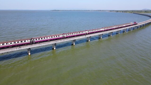 Aerial view of Thailand Excursion train parked on the floating railway bridge for tourists to take a pictures in the lake of Pa Sak Jolasid dam at Lopburi province, amazing Thailand