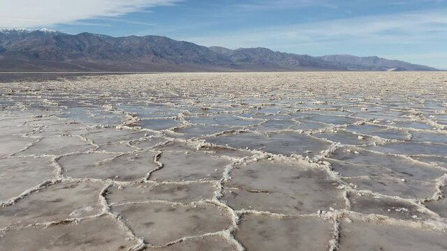 Salt rings in water at Badwater basin with Panamint mountains in the background at Death Valley National Park, CA, USA. Slider left to right.