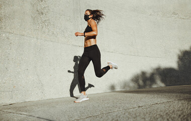 Fototapeta premium Sportswoman with face mask on morning run