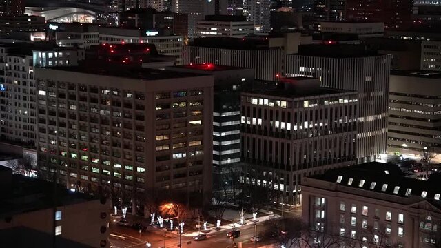 rooftop wet winter night view of downtown city buildings stadium reflection partial post modern historic buildings lit trees and post lights festive style Christmas quite small diagnol birds eye view