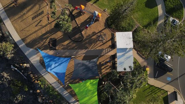 A high view looking down at a colorful playground intertwined with pathways and play equipment for children