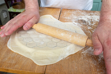 Octagonal metal mold for dumplings,rolled dough for making homemade dumplings. Wooden background...