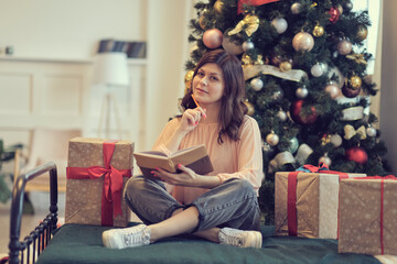 Photo of pretty young lady cuddle paper book. christmas holidays and people concept happy young...