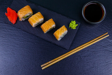 Sushi rolls Philadelphia on a black slate. Top view