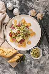 Organic salad. Guacamole, green olives, raw smoked sausage, baguette, ice salad and blue cheese with micro green peas. Dinner in Italian style. Top view