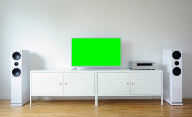 Widescreen modern green screen TV for text and video on a chrome stand against a white wall.	