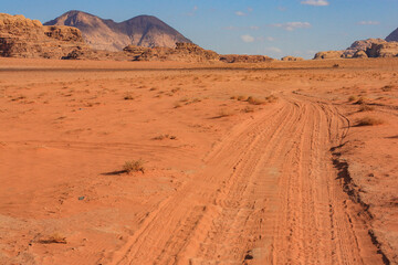 Fototapeta na wymiar empty road in the red desert of Wadi Ram, mountains are on the horizon, nature of Jordan