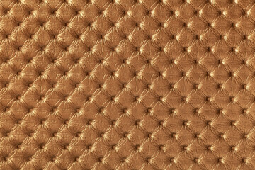 Texture of brown and copper leather background with capitone pattern, macro.