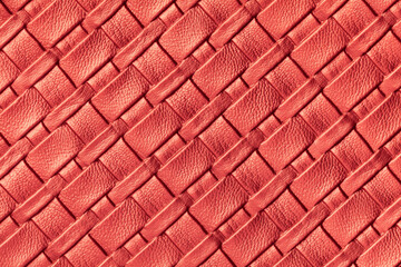 Texture of dark red and rose leather background with wicker pattern, macro.