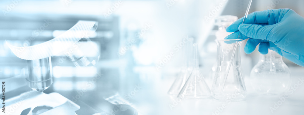 Wall mural hand of scientist in blue glove with flask and microscope in medical science lab banner background.