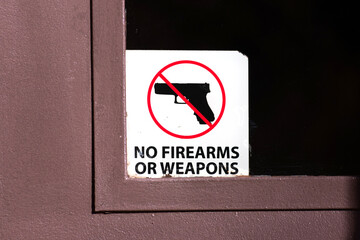 No firearms or weapons sign on the glass entrance door to the business establishment notifies...