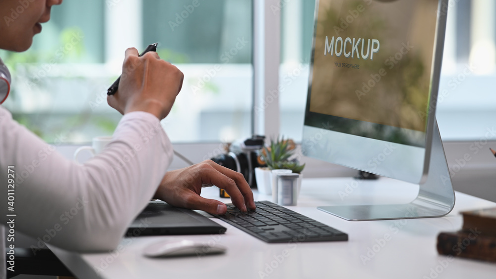 Poster cropped shot of man graphic designer or photographer working with computer and using digital tablet 
