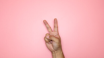 Hand symbol holding 2 fingers isolated on pink background, Blank for design copy space.