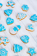 Homemade gingerbread cookies pattern. Christmas gingerbread. Gingerbread man, snowman, heart, star, Christmas tree, snowflake. Decorated sweets for Christmas and New Year on wooden white background