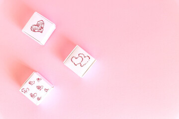 Fototapeta na wymiar Composition of holiday white gift boxes with red hearts on pink background. Happy Valentine's Day, Mother's Day, World Women's Day holiday card concept. Flat lay.Copy space