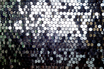 Texture, wall with round silver sequins. The atmosphere of glamour.