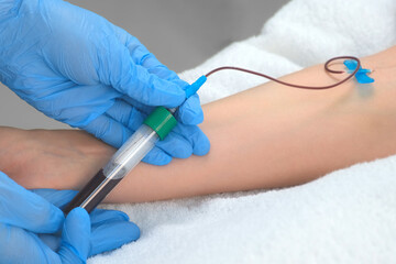 Laboratory worker doctor takes a blood sample for analysis, hand closeup. Blood sampling in the laboratory. Taking a blood in cosmetology clinic before PRP therapy procedure.