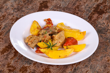 Baked pork meat with potao and tomato
