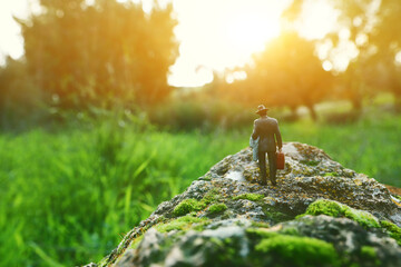 Surreal image of mysterious man walking alone in during sunset